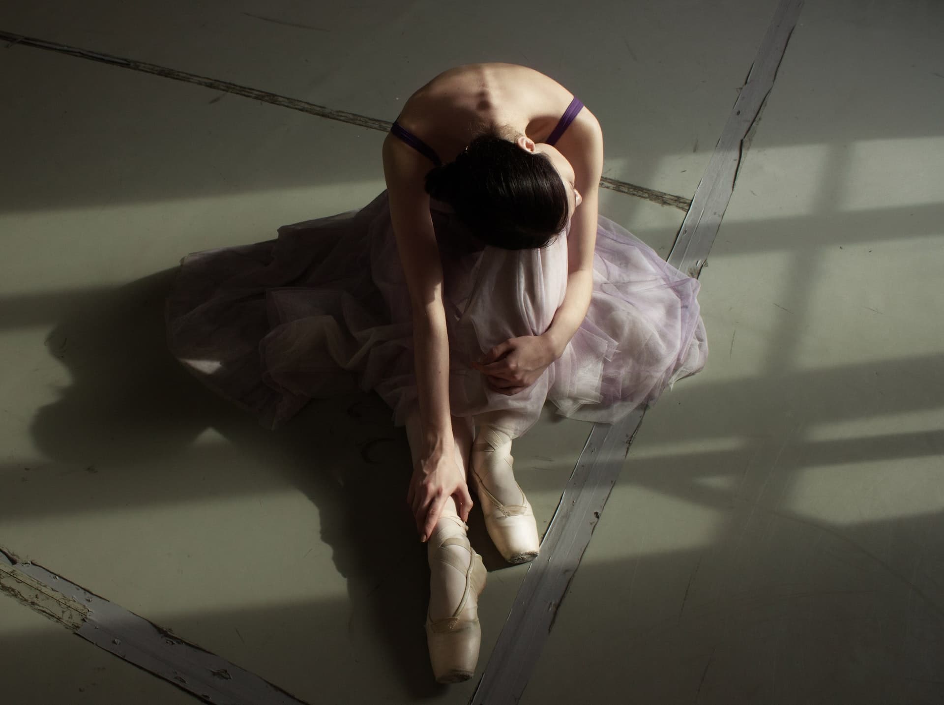 A young female ballet dancer stretches her leg at a ballet dance studio in Dublin, Ireland