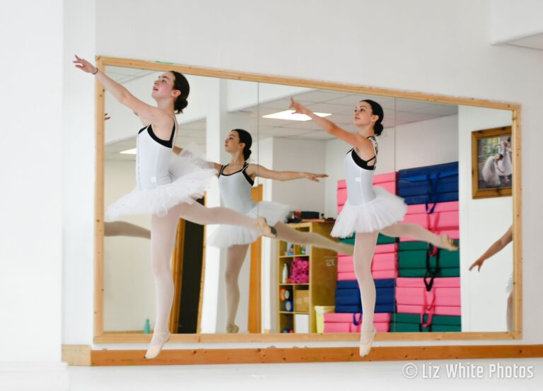 Three very elegant teenage girls in white ballet dresses and black undershirts practice ballet at a Dublin dance studio