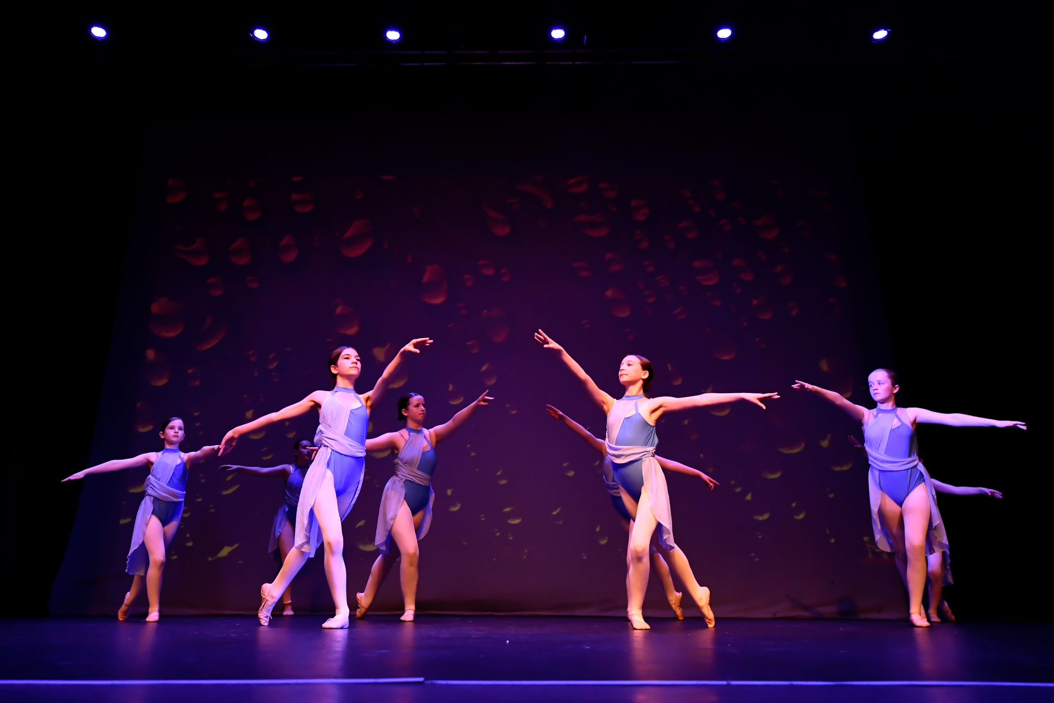 a group of young female contemporary ballet dance student in blue dresses perform modern ballet dance on stage at a ballet show for Ruth Shine School of Dance ballet academy in Dublin, Ireland